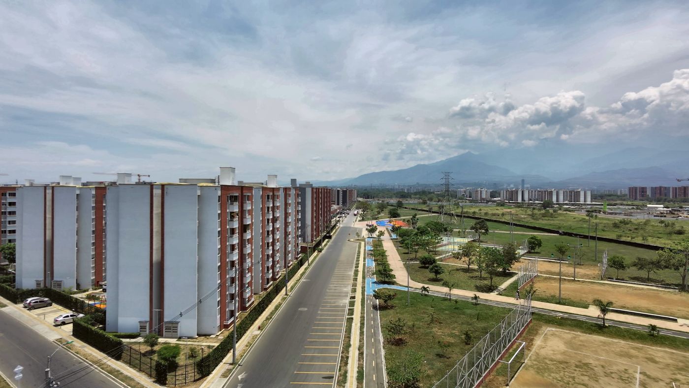 Vía, ciclovía y edificios con las montañas de Cali al fondo
